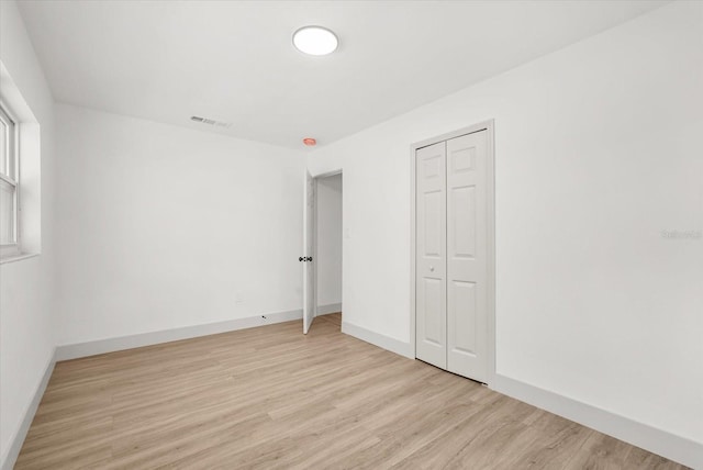 304 W 24th St, Sanford, FL 32771 - unfurnished bedroom featuring light wood-type flooring, a closet, and baseboards