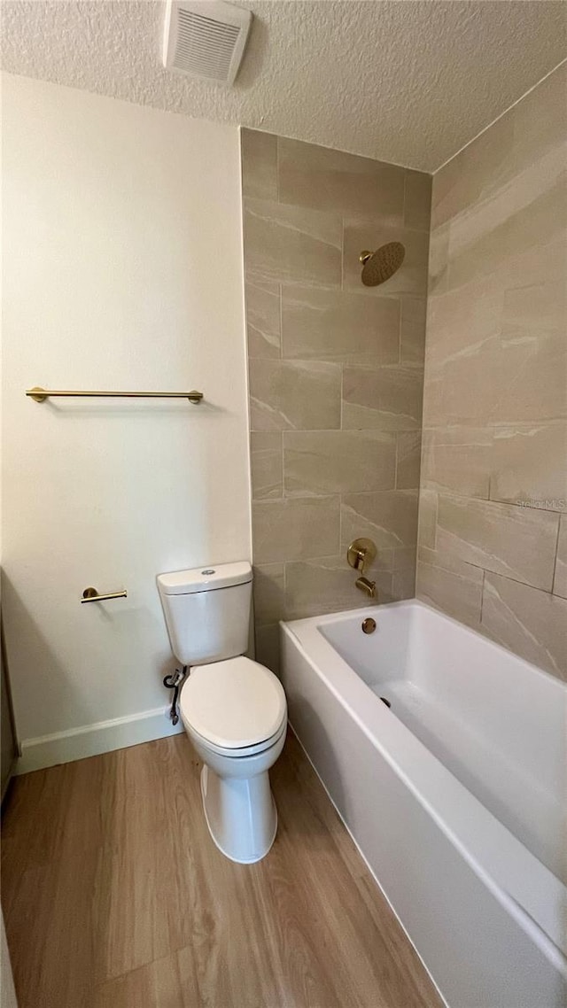 560 Gateway Dr, Merritt Island, FL 32952 - full bathroom with a textured ceiling, wood finished floors, shower / bathtub combination, toilet, and baseboards