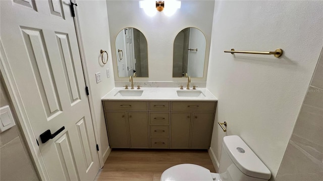 560 Gateway Dr, Merritt Island, FL 32952 - full bathroom featuring toilet, wood finished floors, and double vanity