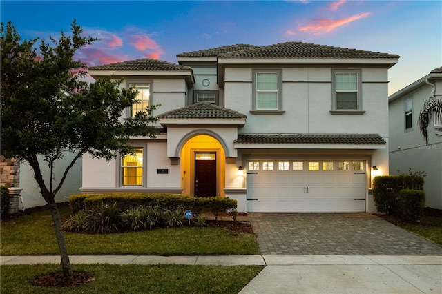 1560 Maidstone Ct, Davenport, FL 33896 - view of front facade with decorative driveway, a tiled roof, stucco siding, and an attached garage