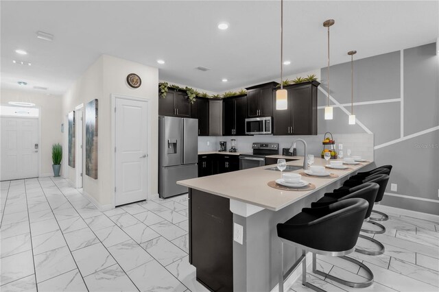 1560 Maidstone Ct, Davenport, FL 33896 - kitchen with appliances with stainless steel finishes, light marble finish floors, a peninsula, light countertops, and baseboards