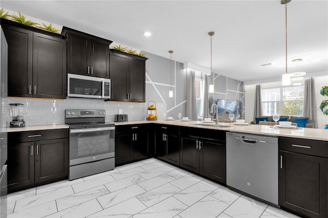 1560 Maidstone Ct, Davenport, FL 33896 - kitchen featuring stainless steel appliances, a sink, light marble finish floors, light countertops, and backsplash