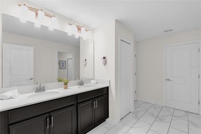 1560 Maidstone Ct, Davenport, FL 33896 - bathroom with double vanity, marble finish flooring, and baseboards