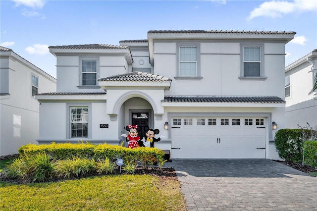 1560 Maidstone Ct, Davenport, FL 33896 - view of front facade with a tiled roof, decorative driveway, stucco siding, and an attached garage