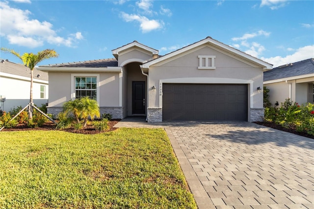 11330 Burgundy Dr, Venice, FL 34293 - ranch-style home featuring stucco siding, a garage, stone siding, a front yard, and decorative driveway