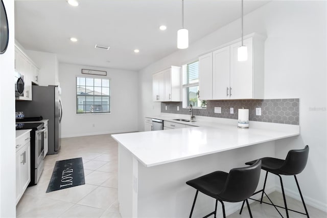 11330 Burgundy Dr, Venice, FL 34293 - kitchen featuring appliances with stainless steel finishes, a sink, backsplash, light countertops, and plenty of natural light