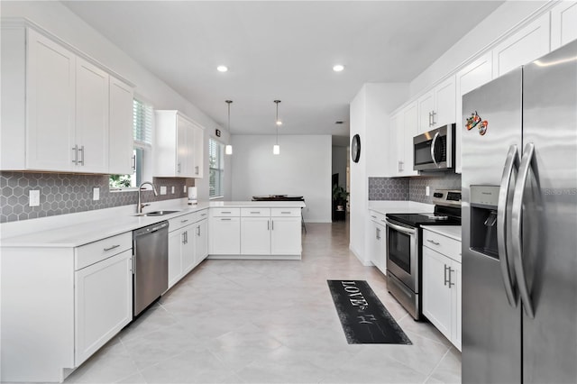 11330 Burgundy Dr, Venice, FL 34293 - kitchen with stainless steel appliances, a sink, a peninsula, backsplash, and white cabinets