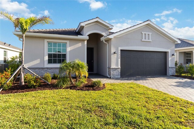 11330 Burgundy Dr, Venice, FL 34293 - ranch-style home featuring stone siding, stucco siding, a garage, and a front yard