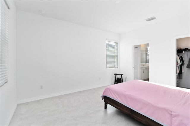 11330 Burgundy Dr, Venice, FL 34293 - bedroom with a walk in closet, connected bathroom, baseboards, and a closet