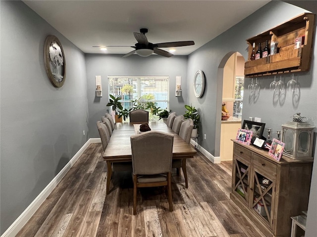 4447 Maple Chase Trl, Kissimmee, FL 34758 - dining area with arched walkways, a ceiling fan, dark wood finished floors, and baseboards