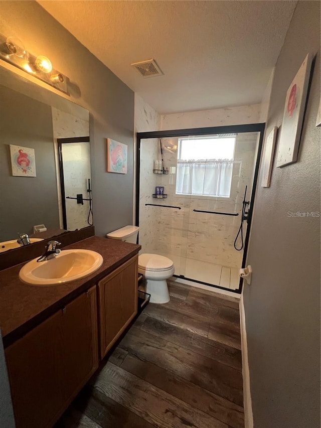 4447 Maple Chase Trl, Kissimmee, FL 34758 - full bath featuring wood finished floors, vanity, a shower stall, toilet, and a textured ceiling