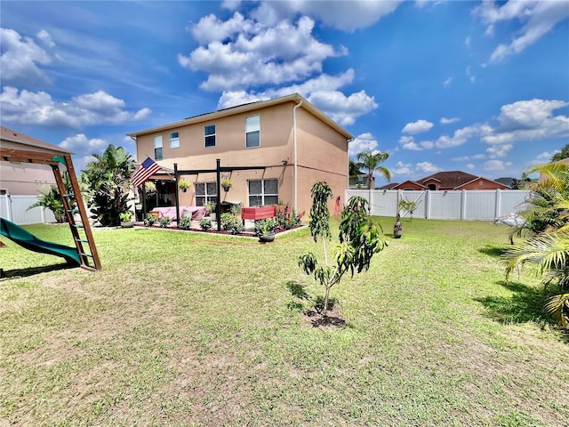 4447 Maple Chase Trl, Kissimmee, FL 34758 - back of property with stucco siding, a playground, and a pergola