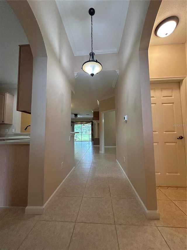 3244 River Branch Cir, Kissimmee, FL 34741 - corridor featuring light tile patterned floors, ornamental molding, baseboards, and arched walkways