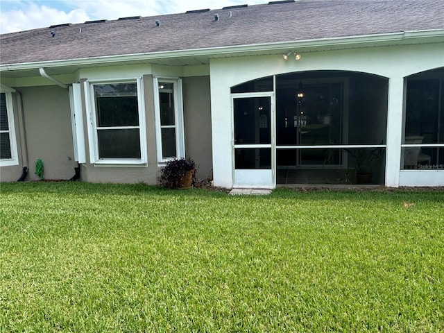 3244 River Branch Cir, Kissimmee, FL 34741 - rear view of house with a sunroom, stucco siding, roof with shingles, and a yard