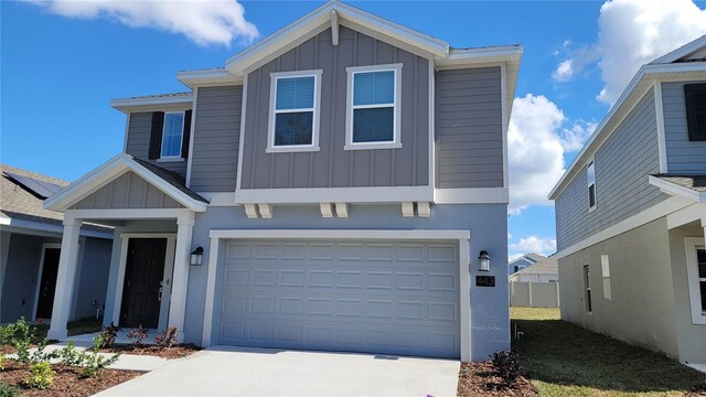 443 Cool Summer Ln, Davenport, FL 33837 - view of front facade featuring board and batten siding, an attached garage, and concrete driveway