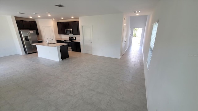 443 Cool Summer Ln, Davenport, FL 33837 - kitchen featuring appliances with stainless steel finishes, open floor plan, light countertops, a sink, and an island with sink