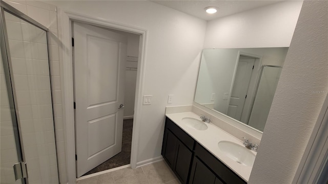 443 Cool Summer Ln, Davenport, FL 33837 - full bathroom featuring tile patterned flooring, double vanity, a shower stall, baseboards, and a walk in closet