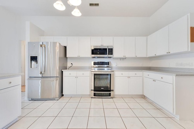 6555 Bay Tree Ct, Saint Cloud, FL 34771 - kitchen featuring stainless steel appliances, light countertops, white cabinetry, light tile patterned floors, and a chandelier
