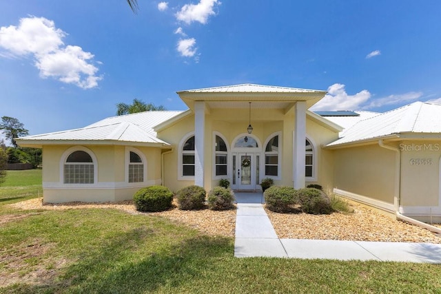 6555 Bay Tree Ct, Saint Cloud, FL 34771 - view of front of home with stucco siding, metal roof, a front yard, and french doors