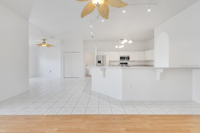 6555 Bay Tree Ct, Saint Cloud, FL 34771 - kitchen featuring stainless steel appliances, a ceiling fan, light countertops, light tile patterned floors, and a chandelier