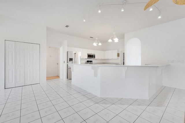 6555 Bay Tree Ct, Saint Cloud, FL 34771 - kitchen featuring stainless steel appliances, light countertops, white cabinets, a chandelier, and a breakfast bar area