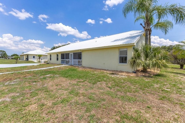 6555 Bay Tree Ct, Saint Cloud, FL 34771 - rear view of property with stucco siding, a yard, a sunroom, and metal roof