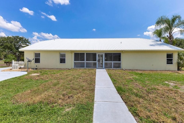 6555 Bay Tree Ct, Saint Cloud, FL 34771 - rear view of house featuring stucco siding, a sunroom, a yard, and metal roof