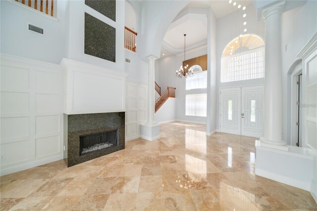 2333 Pinehurst Ct, Davenport, FL 33837 - foyer featuring a high ceiling, decorative columns, a decorative wall, stairs, and a tile fireplace