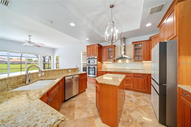 2333 Pinehurst Ct, Davenport, FL 33837 - kitchen with wall chimney exhaust hood, appliances with stainless steel finishes, a sink, brown cabinets, and recessed lighting