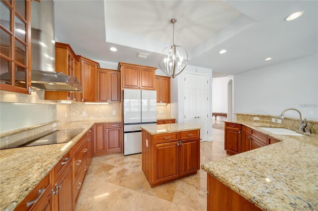 2333 Pinehurst Ct, Davenport, FL 33837 - kitchen with refrigerator, wall chimney range hood, arched walkways, a tray ceiling, and recessed lighting