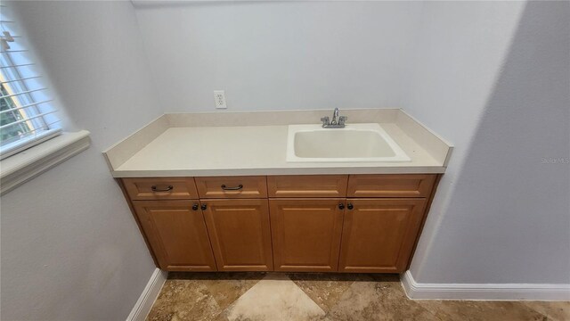 2333 Pinehurst Ct, Davenport, FL 33837 - bathroom featuring baseboards, vanity, and stone finish flooring