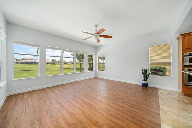2333 Pinehurst Ct, Davenport, FL 33837 - unfurnished living room featuring ceiling fan, light wood-type flooring, and baseboards