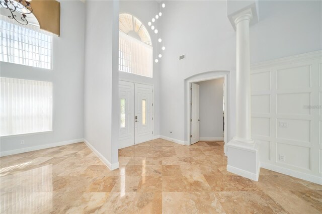 2333 Pinehurst Ct, Davenport, FL 33837 - foyer with decorative columns, a towering ceiling, plenty of natural light, and baseboards