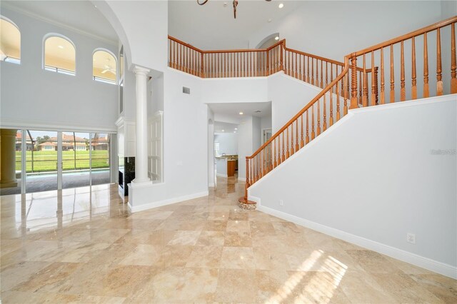 2333 Pinehurst Ct, Davenport, FL 33837 - foyer entrance featuring ornate columns, a high ceiling, stairs, baseboards, and marble tiled floors