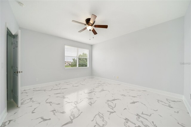 2333 Pinehurst Ct, Davenport, FL 33837 - empty room featuring ceiling fan, marble look tiles, and baseboards