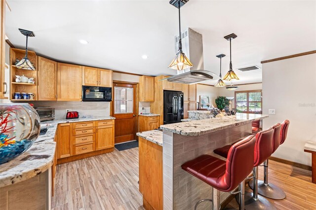 1096 Dyson Dr, Winter Springs, FL 32708 - kitchen featuring black appliances, island range hood, light wood-style flooring, a breakfast bar area, and crown molding