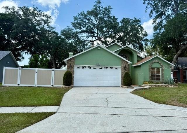 2779 Theresa Dr, Kissimmee, FL 34744 - ranch-style house with concrete driveway, an attached garage, and a gate