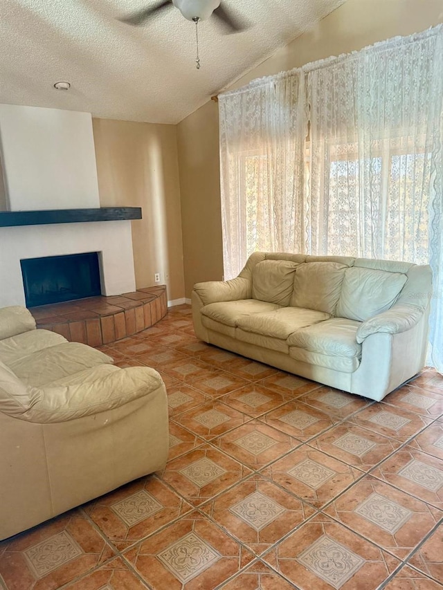 2779 Theresa Dr, Kissimmee, FL 34744 - living room featuring a textured ceiling, healthy amount of natural light, a large fireplace, a ceiling fan, and vaulted ceiling