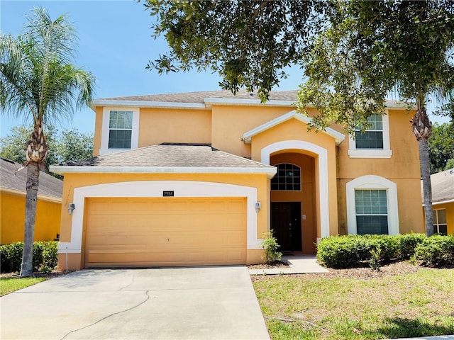 2514 Dharma Cir, Kissimmee, FL 34746 - view of front of property featuring stucco siding, an attached garage, a shingled roof, and concrete driveway