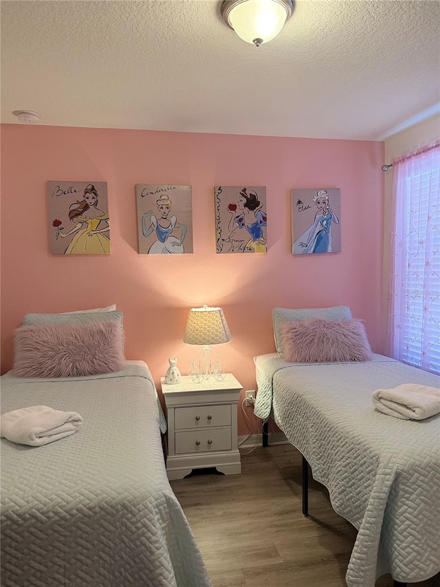 2514 Dharma Cir, Kissimmee, FL 34746 - bedroom featuring wood finished floors and a textured ceiling
