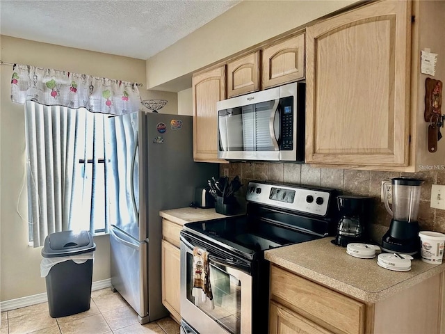 2734 Rio Grande Trl Unit 2734, Kissimmee, FL 34741 - kitchen featuring stainless steel appliances, light brown cabinets, decorative backsplash, light countertops, and a textured ceiling