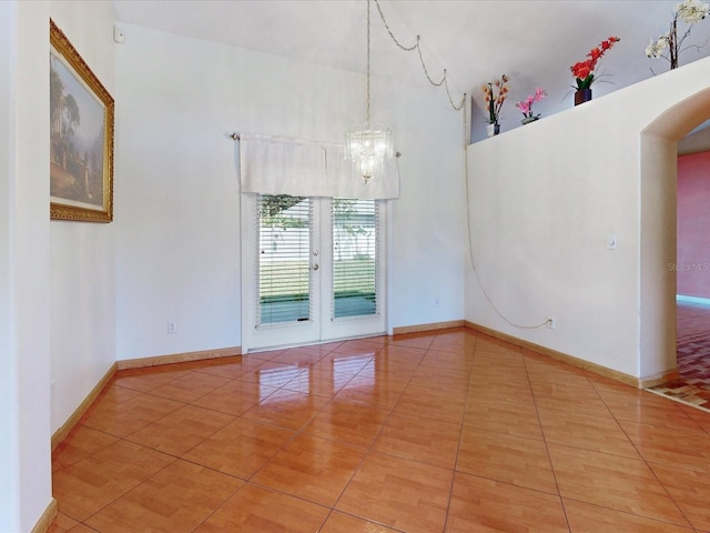 3811 Gator Bay Ln, Saint Cloud, FL 34772 - tiled spare room with a towering ceiling, arched walkways, a chandelier, baseboards, and french doors