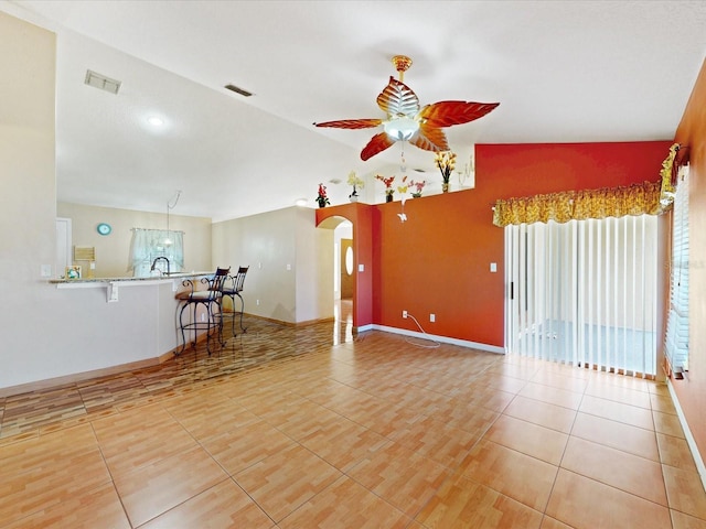 3811 Gator Bay Ln, Saint Cloud, FL 34772 - unfurnished living room featuring ceiling fan, light tile patterned flooring, arched walkways, baseboards, and lofted ceiling