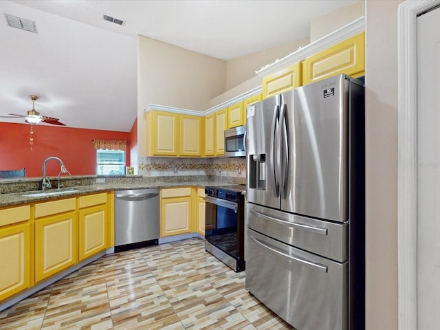 3811 Gator Bay Ln, Saint Cloud, FL 34772 - kitchen featuring stainless steel appliances, a sink, a ceiling fan, vaulted ceiling, and dark stone countertops