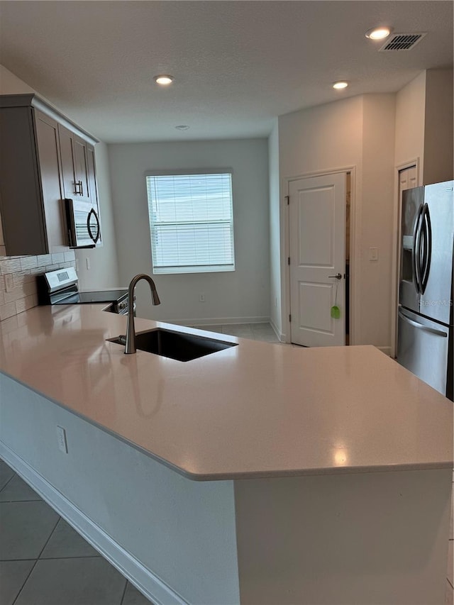 4053 Redbridge Loop, Davenport, FL 33837 - kitchen with appliances with stainless steel finishes, a sink, a peninsula, light countertops, and recessed lighting