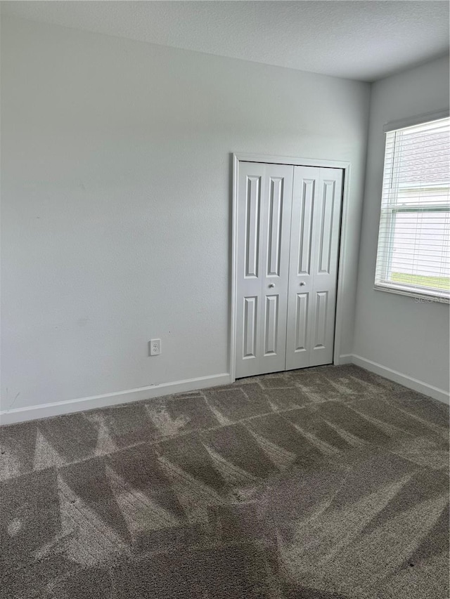 4053 Redbridge Loop, Davenport, FL 33837 - unfurnished bedroom featuring carpet flooring, baseboards, and a closet