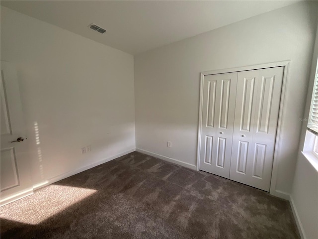 4053 Redbridge Loop, Davenport, FL 33837 - unfurnished bedroom with dark colored carpet, baseboards, and a closet