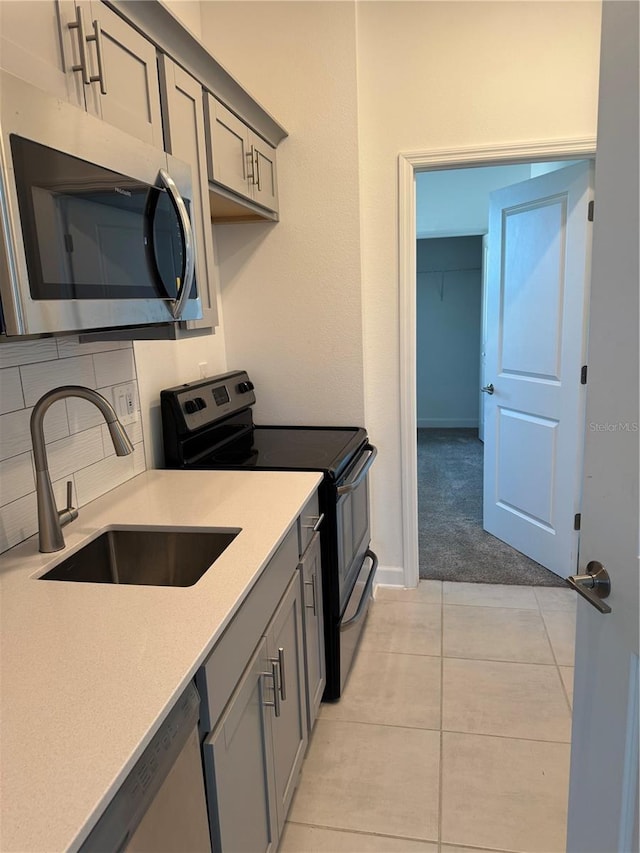 4053 Redbridge Loop, Davenport, FL 33837 - kitchen with appliances with stainless steel finishes, gray cabinetry, a sink, and light countertops