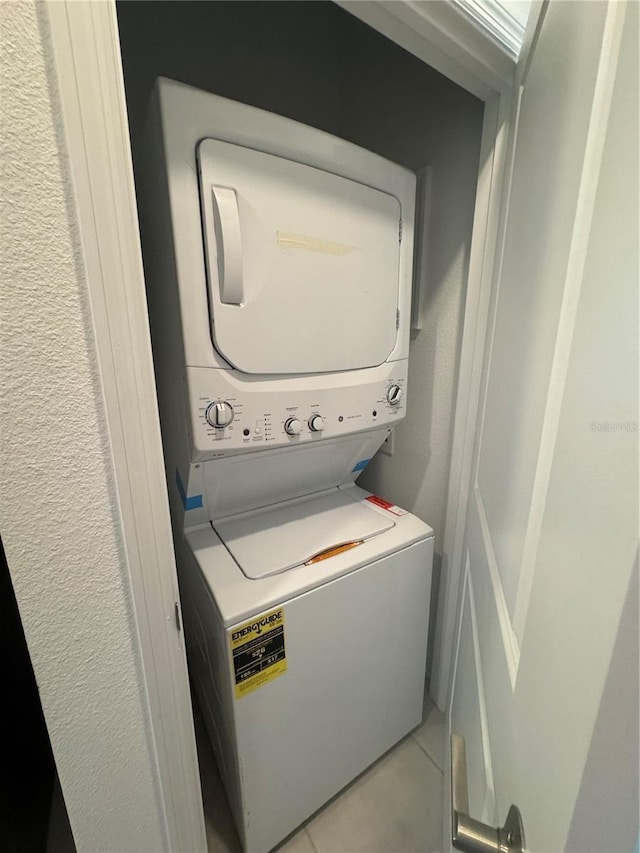 4053 Redbridge Loop, Davenport, FL 33837 - laundry room featuring estacked washer and dryer, a textured wall, and light tile patterned floors