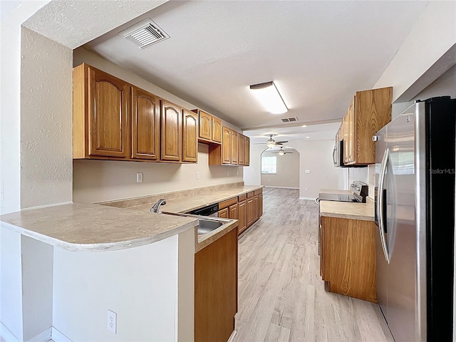 2409 E Magnolia St, Lakeland, FL 33801 - kitchen with appliances with stainless steel finishes, ceiling fan, a peninsula, and brown cabinets